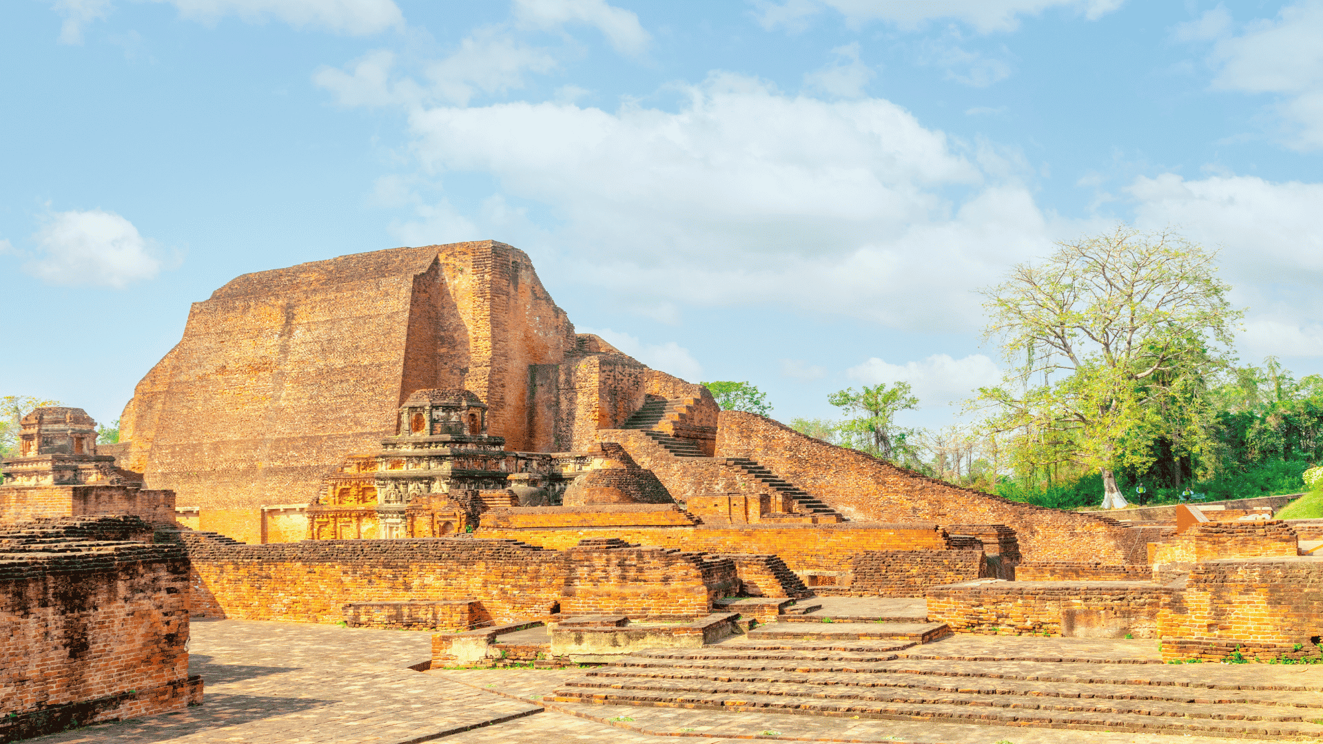 Nalanda Mahavihara.Buddhist monk walking through Nalanda Mahavihara ruins Bihar India